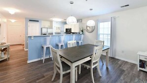 A modern kitchen with white cabinets, a blue island, and pendant lighting. - Green Fairways Retreat Condo (Myrtle Beach)