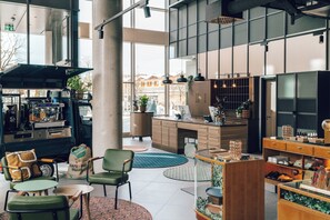 Ein modernes Interieur mit einer Kaffeestation, einer Sitzecke und einer Küche.