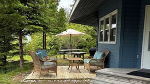 A covered patio with wicker furniture, a table, and an umbrella.