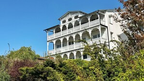 A multi-story building with balconies and a white facade.