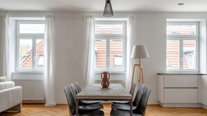 A dining area with a table, chairs, a lamp, and a vase.