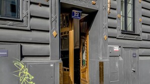 A building entrance with a wooden door and a blue sign above it. - Fabulous Meidling 2BR., Furnished & Equipped, by Blueground (Vienna)
