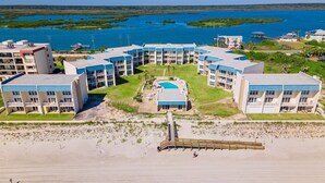 Et strandhotel med flere bygninger, en swimmingpool og en gangbro til stranden.