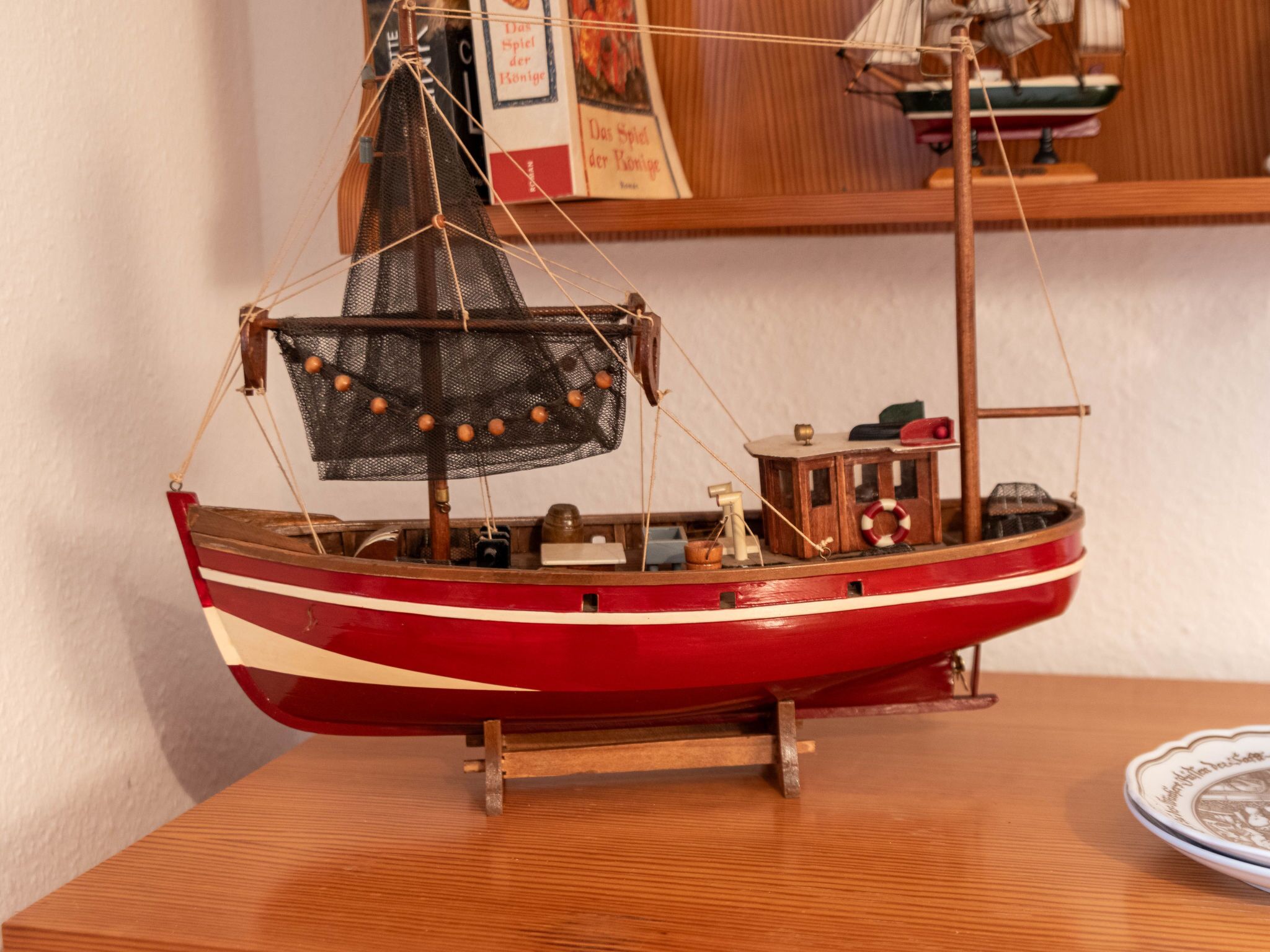 Une maquette de bateau posée sur un socle en bois.