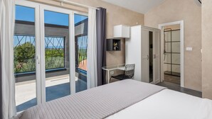 A bedroom with a bed, a desk, a chair, a wardrobe, and a shower. - Villa Nika by Interhome (Krk/Dobrinj)