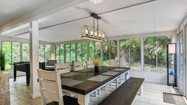 A spacious dining area with a long table, chairs, and a foosball table.