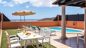 A rooftop terrace with a pool, outdoor seating, and a view of the ocean. - Vista Lobos (La Oliva)