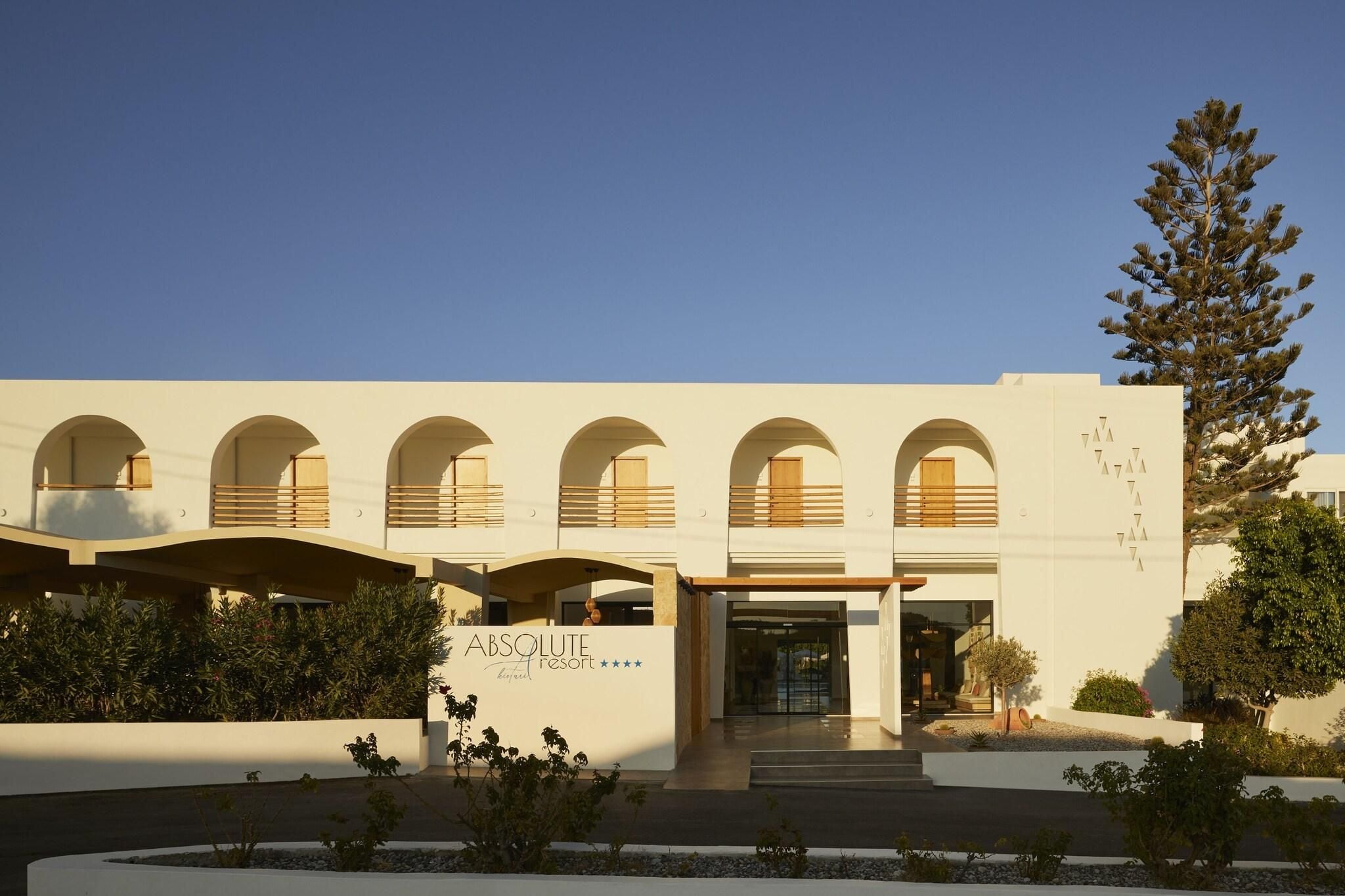 A modern building with a series of arched windows and a sign that reads 'ABSOLUTE resort'.