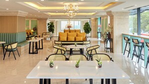 A spacious lobby with a central seating area, a chandelier, and a view of the outdoors. - Union Inn (Tuan Chau)