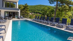 A modern pool area with lounge chairs and a clear view of a hillside. - Visum Mare Tribus by Interhome (Mošćenička Draga)
