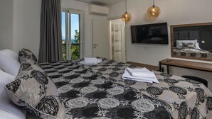 A hotel room with a large bed, a TV, and a balcony with curtains. - Visum Mare Tribus by Interhome (Mošćenička Draga)