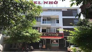 Un bâtiment avec une enseigne indiquant « EL NHÔ » et une devanture de magasin avec une enseigne qui dit « Cafê ».