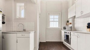 Una cucina moderna con mobili bianchi, un forno in acciaio inossidabile e un microonde.