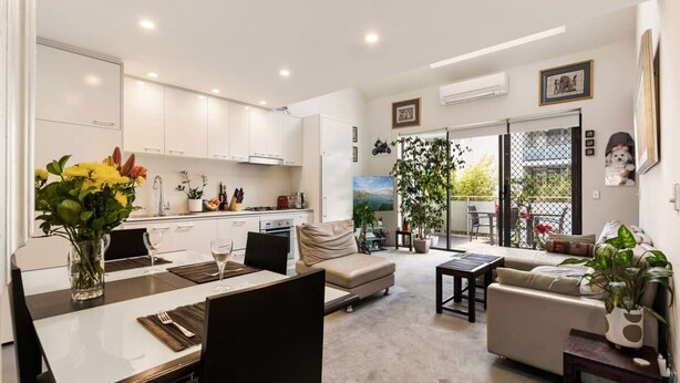 A modern living space with a dining area, kitchen, and seating area. - Poolside Apartment Opposite Redfern Park (Redfern)
