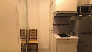 Une cuisine compacte équipée d’un réfrigérateur, d’un four à micro-ondes et d’un petit plan de travail.