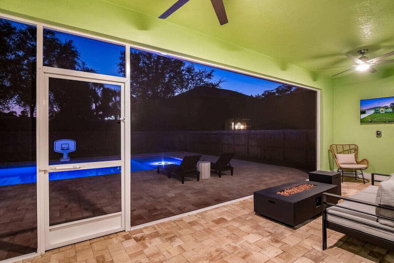 Une terrasse extérieure moderne dotée d’une piscine, d’un espace salon et d’un foyer.