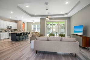 Relax in a spacious living area with a sofa and chairs, kitchen with microwave, and dining table.