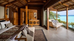 A spacious bedroom with a large bed, a sitting area with a sofa, and a view of the ocean. - Semaya Beach Resort (Penida Island)