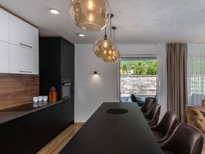 Enjoy cooking in the well-equipped kitchen with oven and dining area adjacent to a poolside view.