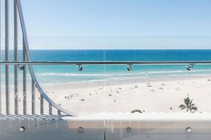 A beach view from a balcony with a railing, clear sky, and ocean. - Kirra Point Holiday Apartments (Coolangatta)