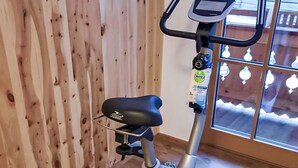 Ein Heimtrainer in einem Raum mit Holzwänden und einem großen Fenster.