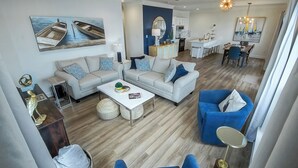 A spacious living room with a sofa set, a coffee table, and a dining area with a table and chairs. - It's About River Time, a 3BR/3BA house on False River, fenced yard & large pier! (Jarreau)