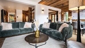 A modern living room with two grey sofas, a round coffee table, and a wooden ceiling. - N°2: Beautiful 10 people apartment with sauna  et  south facing terraces (CHAMPAGNY EN VANOISE)