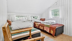 A bedroom with two beds, a wooden bench, a desk, and a window with curtains. - 2 bedroom nice home in Højby (Højby)