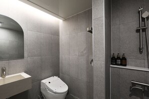 Een moderne badkamer met toilet, wastafel en douchehoek.