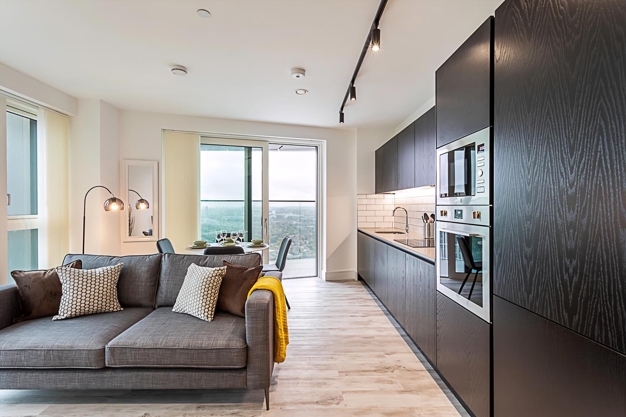 A modern kitchen with dark cabinetry, a built-in oven, and a microwave.