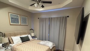 A bedroom with a bed, nightstand, lamp, ceiling fan, and artwork on the wall. - Spacious 3 bedroom Townhome in the heart of Baltimore  (Baltimore)