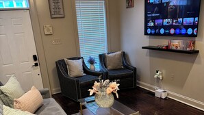 A living room with a sofa, a coffee table, a TV, and a window with blinds. - Spacious 3 bedroom Townhome in the heart of Baltimore  (Baltimore)
