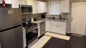 A modern kitchen with white cabinets, stainless steel appliances, and a granite countertop. - Spacious 3 bedroom Townhome in the heart of Baltimore  (Baltimore)