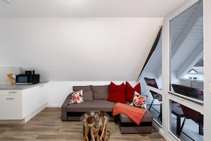 Ein modernes Wohnzimmer mit Sofa, Couchtisch und Blick ins Freie.