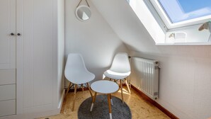 A room with a skylight, white walls, a radiator, and two white chairs. - Apartment 'Jule' with Shared Terrace, Shared Garden and Wi-Fi (Pellworm)