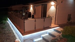 A house with a covered patio, outdoor seating, and a staircase leading to the entrance. - Holiday Home 'Stauseeblick' with Lake View, Private Terrace and Wi-Fi (Kelbra)