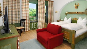 Un dormitorio con una cama, un escritorio, una silla y un sofá rojo.