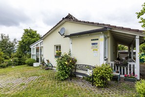 En bygning med parabol, bænk og plantekasser.