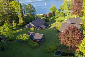 A residential area with houses, a lawn, and a body of water. - Holiday Home 'Eiderblick' with Private Terrace, Private Garden and Wi-Fi (Borgstedt)