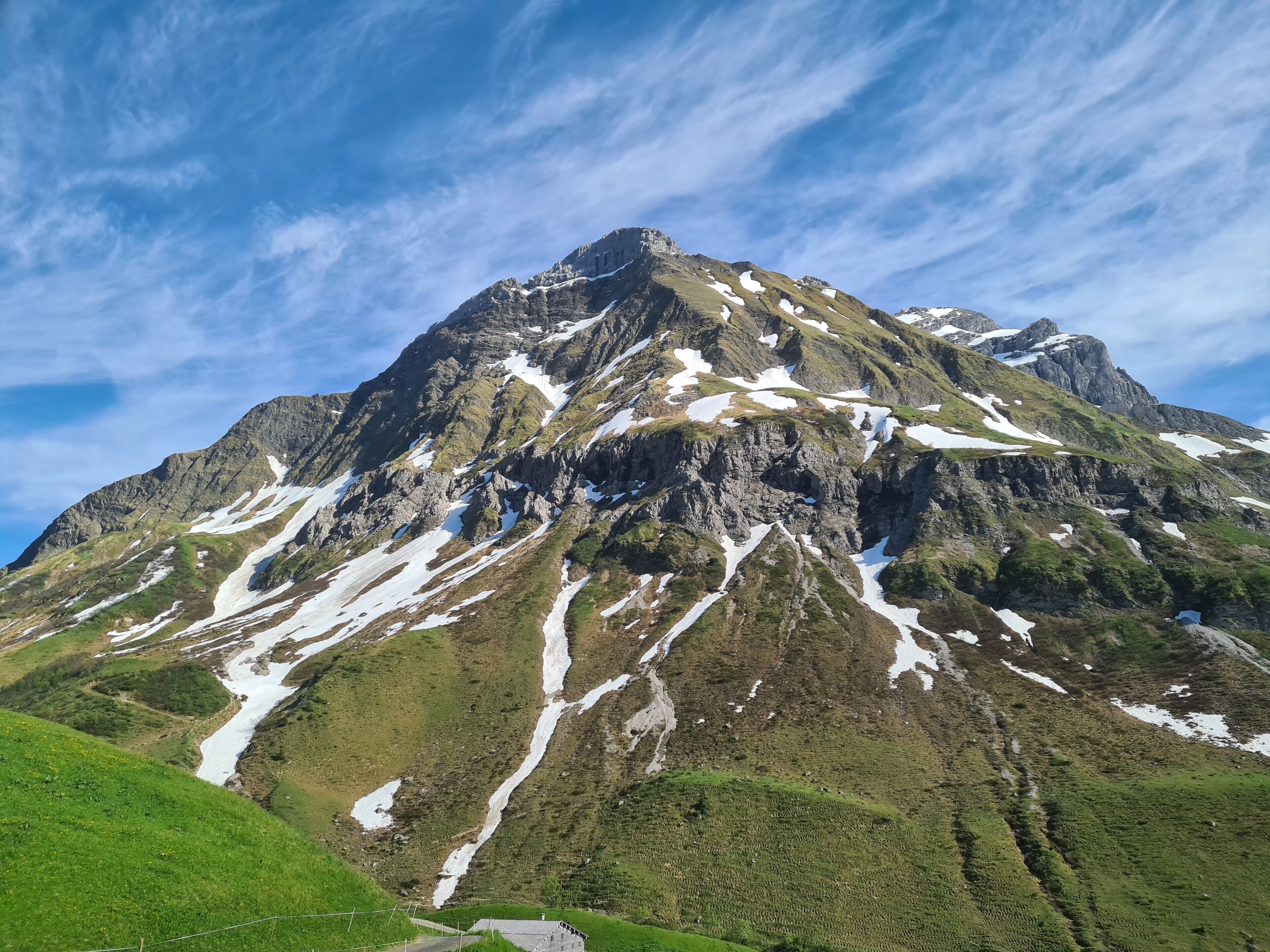 Ein Berg mit Schneeflecken und einem klaren Himmel.