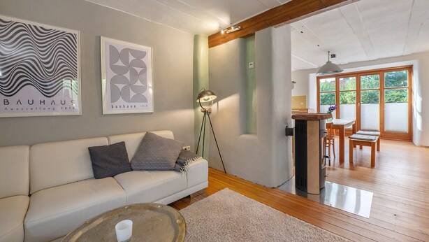 Een moderne woonkamer met een bank, salontafel en kunstwerk aan de muur.