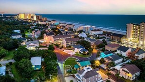 A coastal town with residential buildings, a beachfront, and high-rise hotels. - Modern 7BR Triplex | Sleeps 20 | Steps to Beach (North Myrtle Beach)