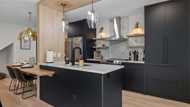 A modern kitchen with a central island, black cabinetry, and a wooden ceiling. - Modern 7BR Triplex | Sleeps 20 | Steps to Beach (North Myrtle Beach)