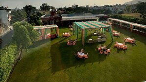 A rooftop terrace with a green lawn and outdoor seating area. - Hotel white inn (Haldwani)