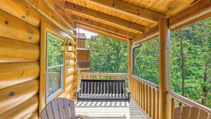 A wooden deck with a bench and chairs, overlooking a forested area. - 'Shady Pines' Mountain Retreat w/ Hot Tub! (Sevierville)