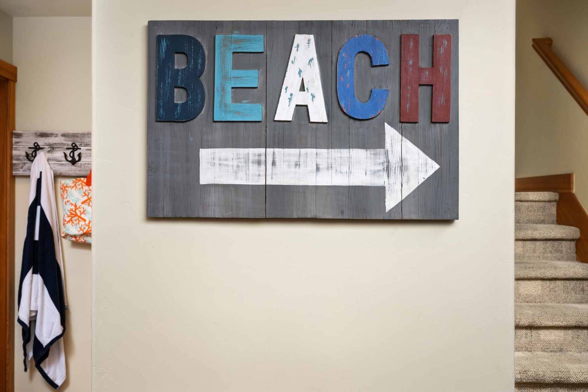 Une enseigne murale avec le mot « PLAGE » et une flèche pointant vers la droite.