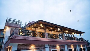 A multi-story building with a rooftop terrace, brick walls, and a metal railing. - Hongsi Hotel (Kathmandu)