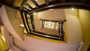 A spiral staircase with a central light fixture and wooden railings. - Hongsi Hotel (Kathmandu)