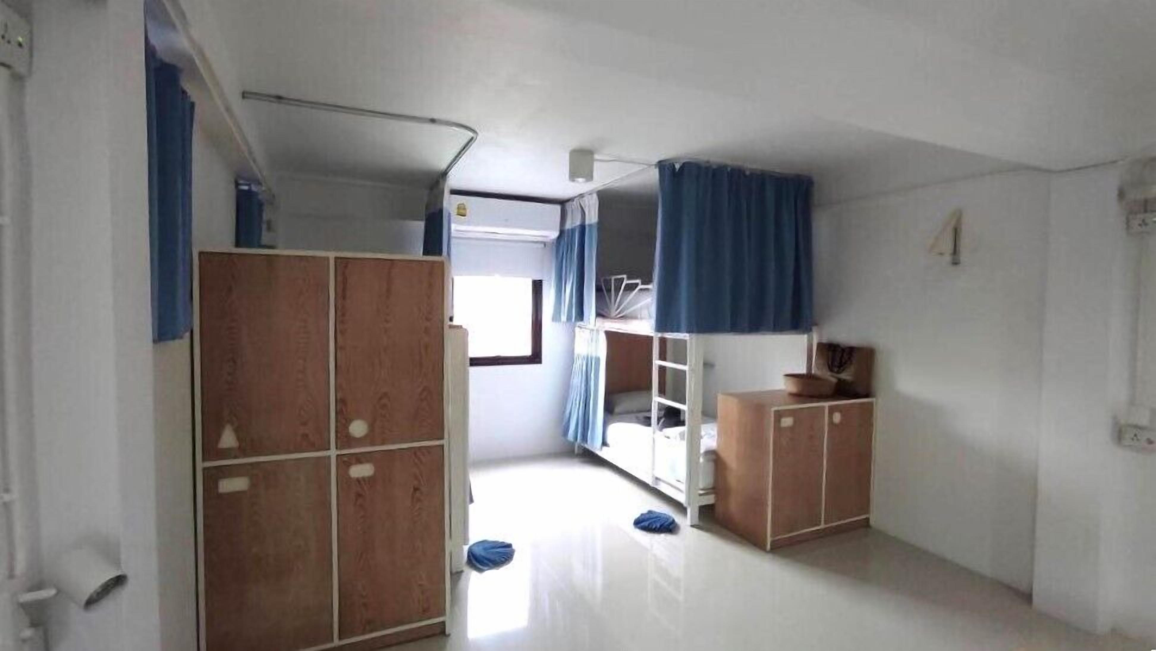 Une chambre avec des lits superposés, une armoire et une petite table avec un bol.