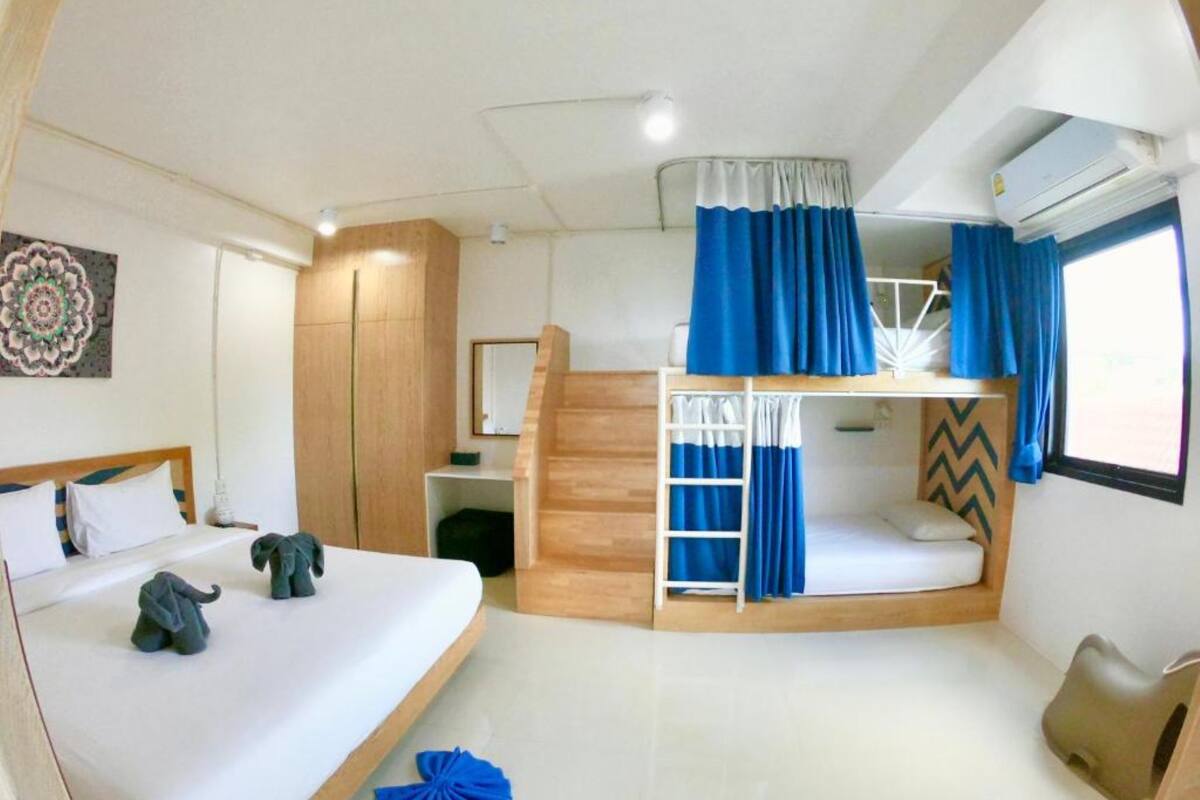 A bunk bed room with a desk, a chair, and a small elephant decoration.